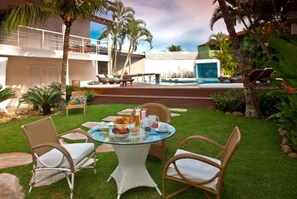Una piscina al aire libre, sillones reclinables de piscina