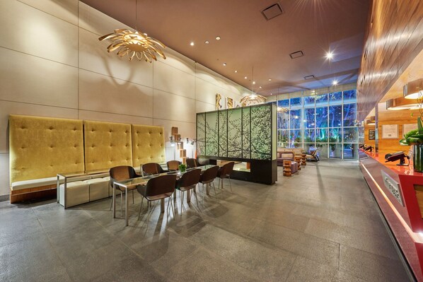A modern hotel lobby with a large seating area, a reception desk, and a view through large windows. - City Express Plus by Marriott Ciudad de México Reforma El Ángel (Mexico City)