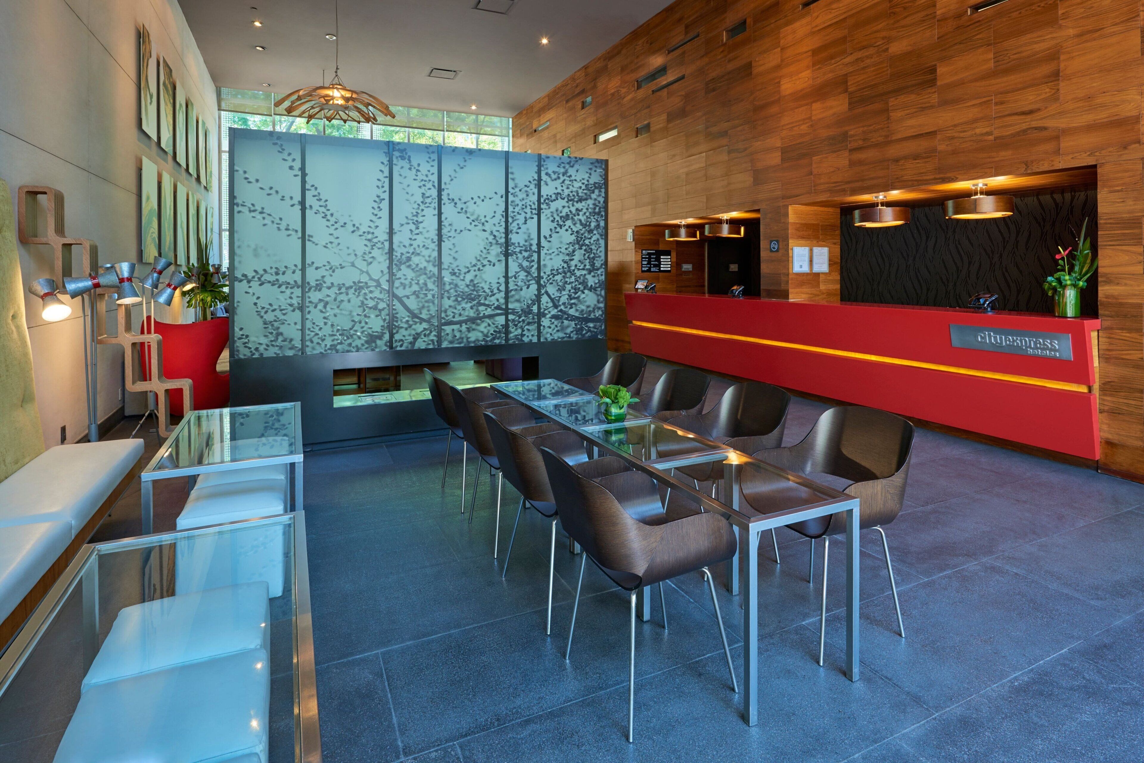 Un moderno vestíbulo de hotel con mostrador de recepción, zona de estar y un amplio ventanal.