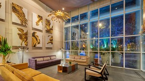 A modern lobby with large windows, a sofa, a coffee table, and artwork on the walls. - City Express Plus by Marriott Ciudad de México Reforma El Ángel (Mexico City)