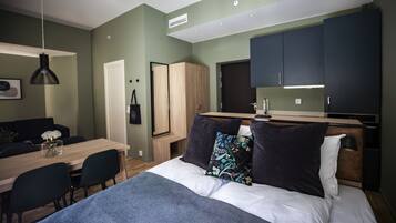 Une chambre moderne équipée d’un lit, d’un bureau et d’une kitchenette.