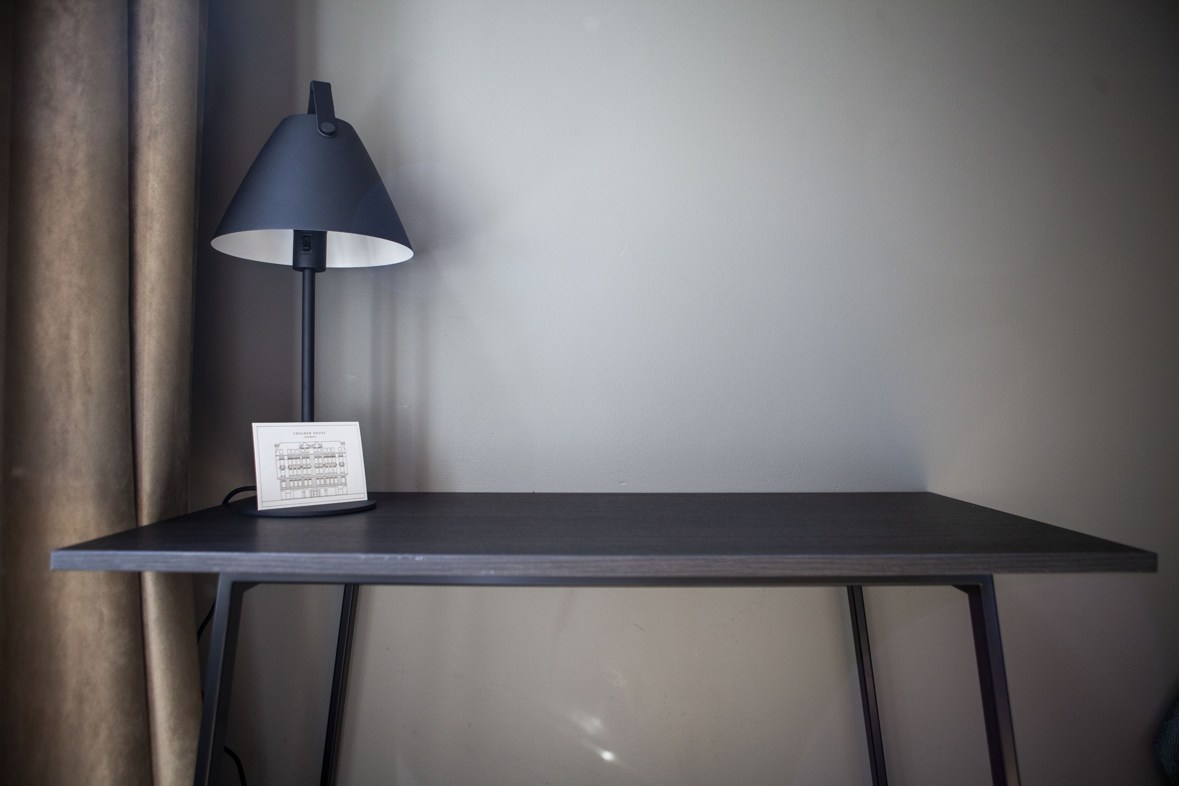 Et bord med en sort lampe og et skilt på.