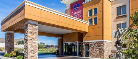 A Comfort Inns hotel with a modern design, featuring a covered entrance and stone pillars.