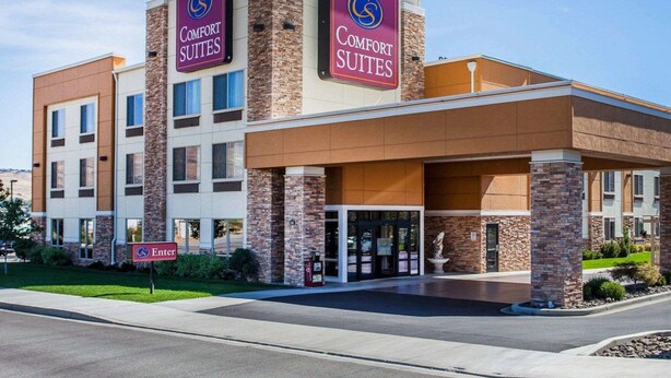 Um hotel Comfort Suites com design moderno, apresentando uma entrada e sinalização em destaque.