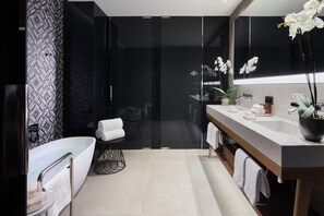 A modern bathroom with a freestanding bathtub, a vanity with a mirror, and a large mirror reflecting the room. - Mandarin Oriental, Barcelona (Barcelona)