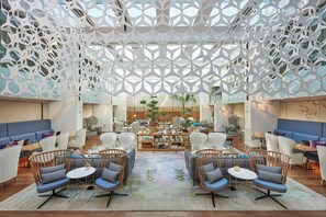 A spacious lobby with a geometric ceiling design, comfortable seating areas, and a central dining space. - Mandarin Oriental, Barcelona (Barcelona)