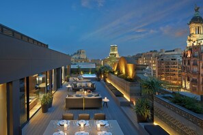 A rooftop terrace with outdoor seating, a pool, and a view of the city skyline at dusk. - Mandarin Oriental, Barcelona (Barcelona)