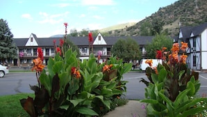 A hotel with a traditional architectural style, featuring multiple balconies and a parking lot in front. - Silver Spruce Inn (Glenwood Springs)