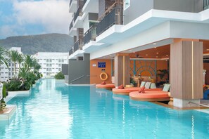 A hotel pool area with a clear view of the mountains in the background, a lounge with seating, and a sign indicating the pool's depth. - Andakira Hotel (Patong)
