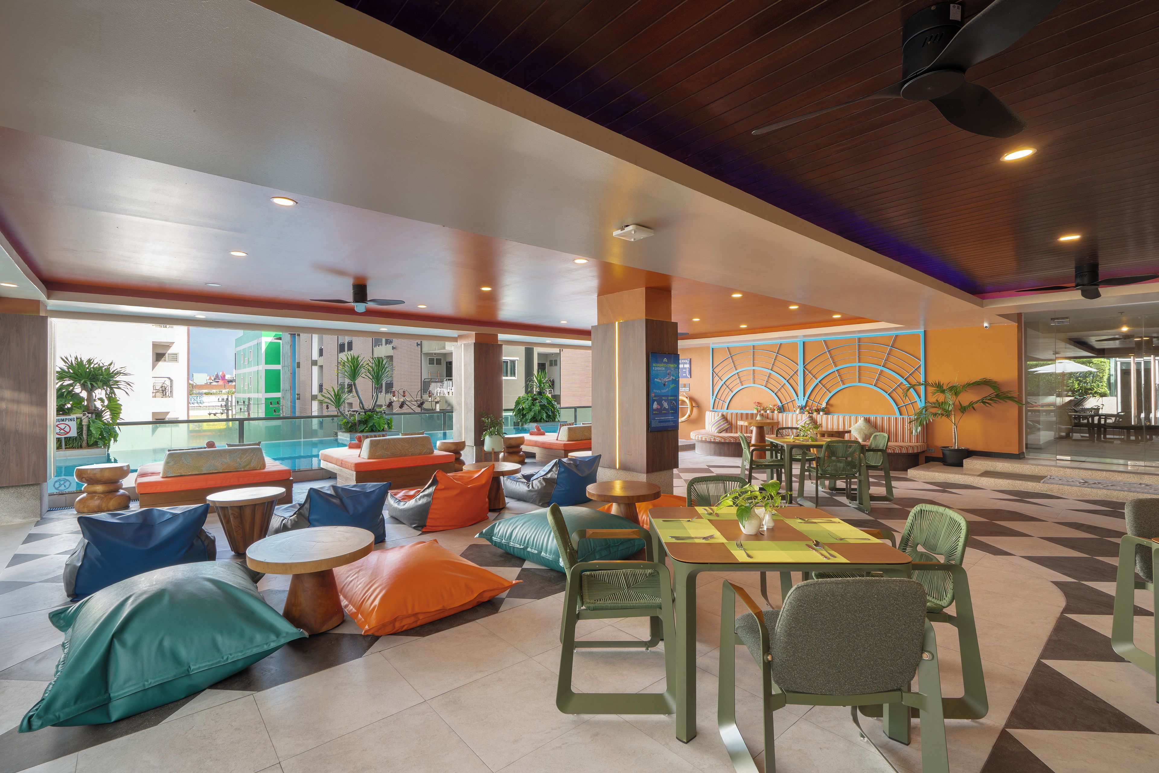 A spacious indoor area with seating arrangements, a pool, and a dining area.