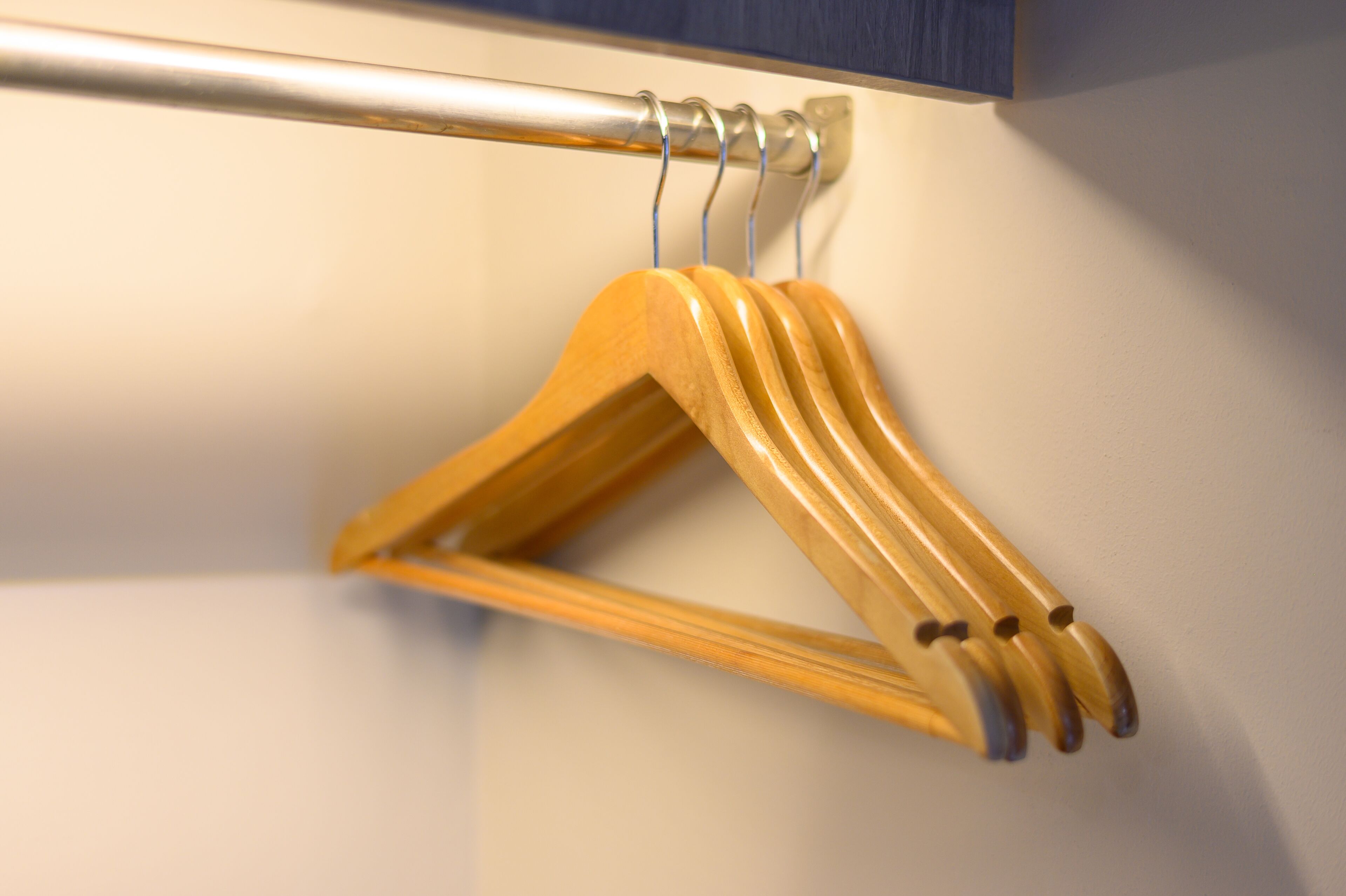 A wooden hanger on a metal rod.