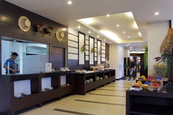A buffet area with a long counter, multiple serving stations, and a variety of dishes displayed. - Andakira Hotel (Patong)