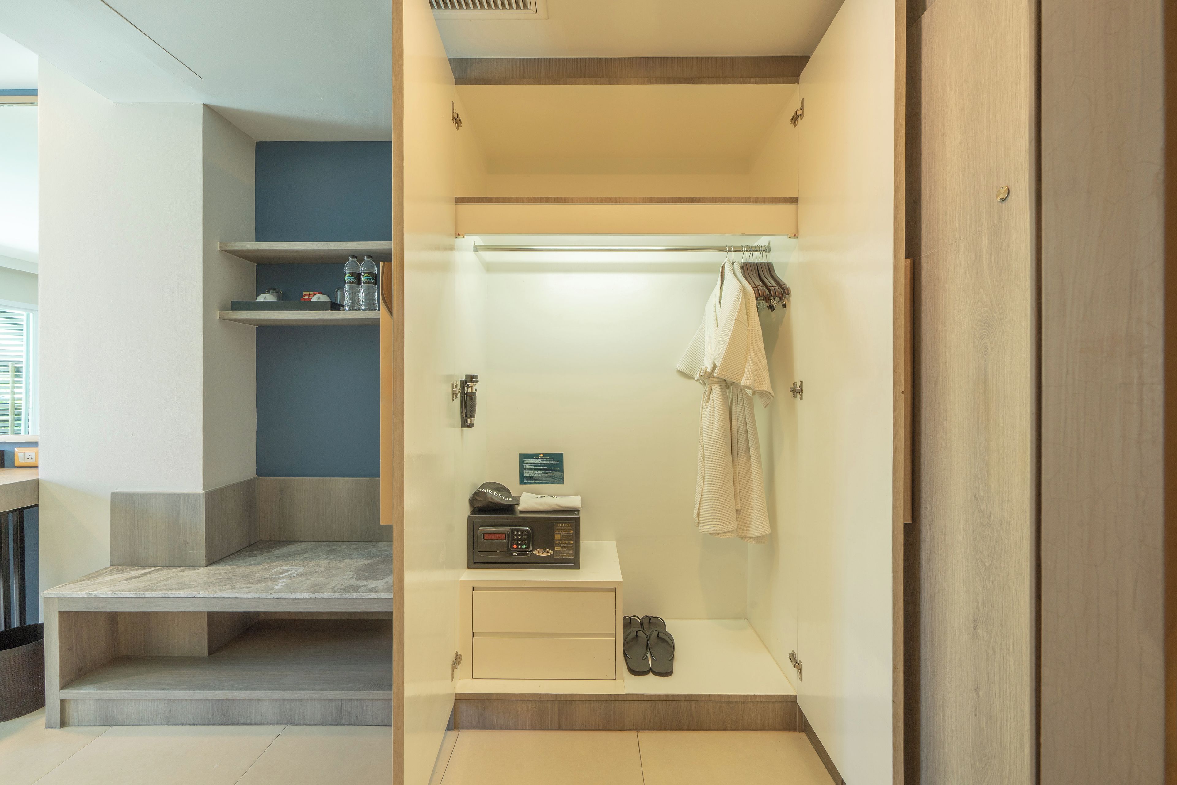Casa de banho moderna com chuveiro, secador de cabelo e porta-toalhas.