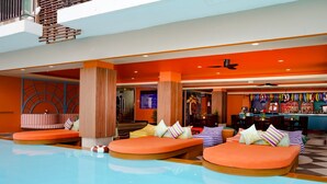 A modern indoor pool area with lounge seating and a bar. - Andakira Hotel (Patong)