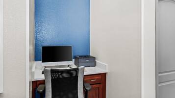 Un pequeño espacio de oficina con un escritorio, una computadora e impresora.