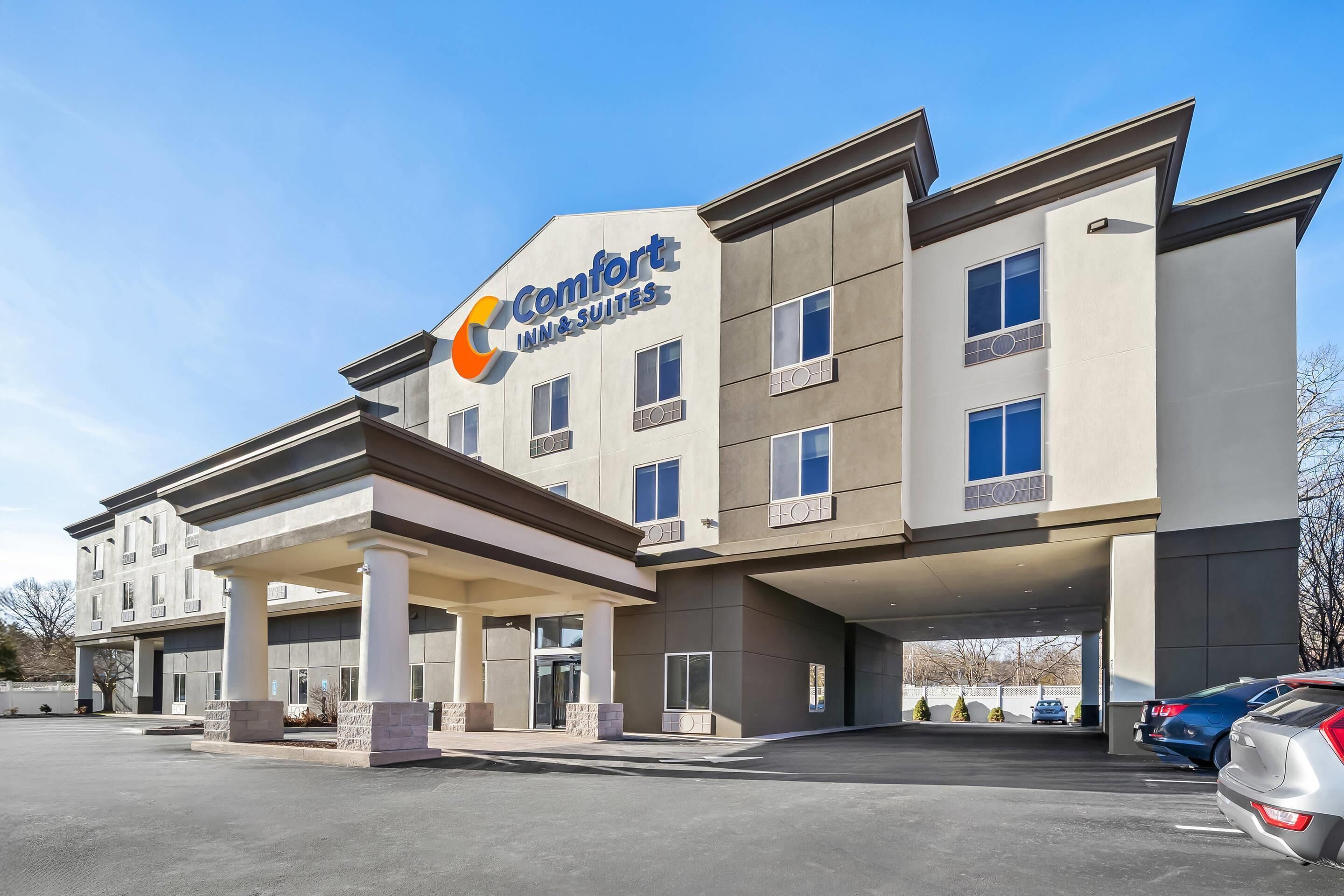 A Comfort Inn & Suites building with a modern architectural design, featuring a covered entrance and multiple windows.