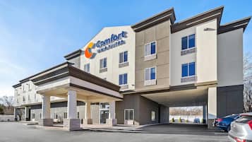 A Comfort Inn & Suites building with a modern architectural design, featuring a covered entrance and multiple windows.