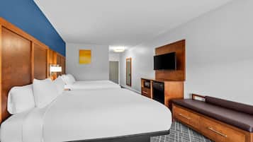 Ein Hotelzimmer mit einem großen Bett, einem Schreibtisch, einem Fernseher und einer Sitzbank.