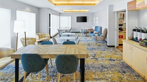 A modern hotel room with a large bed, a desk, and a dining area. - TownePlace Suites by Marriott Farmington (Farmington)