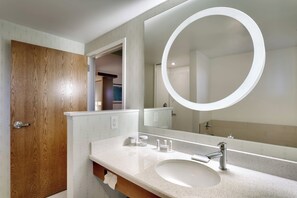 Bathroom features a large mirror, white sink, and chrome faucet.