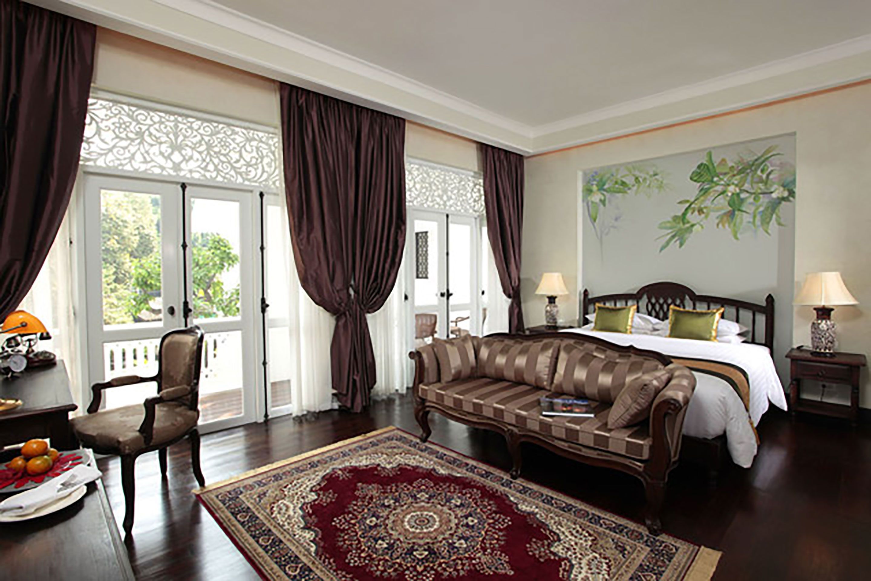 Una habitación de hotel con una cama grande, un sofá, una silla y una mesa de comedor.
