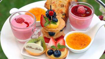 Una bandeja con diversos postres, incluyendo tartaletas de fruta, crema pastelera y una porción de pastel.