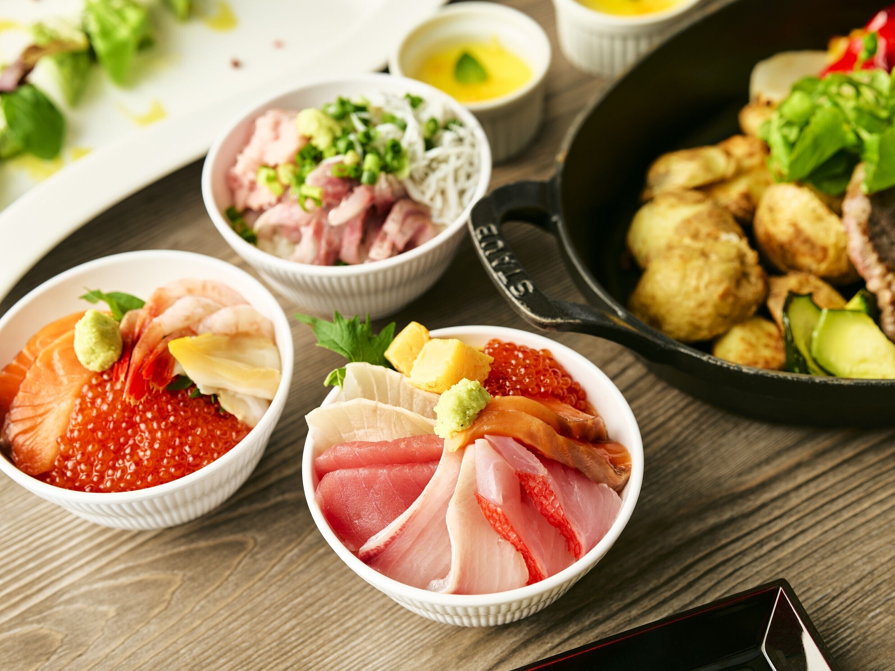 A variety of sushi dishes, including sashimi and nigiri, served on a wooden table.
