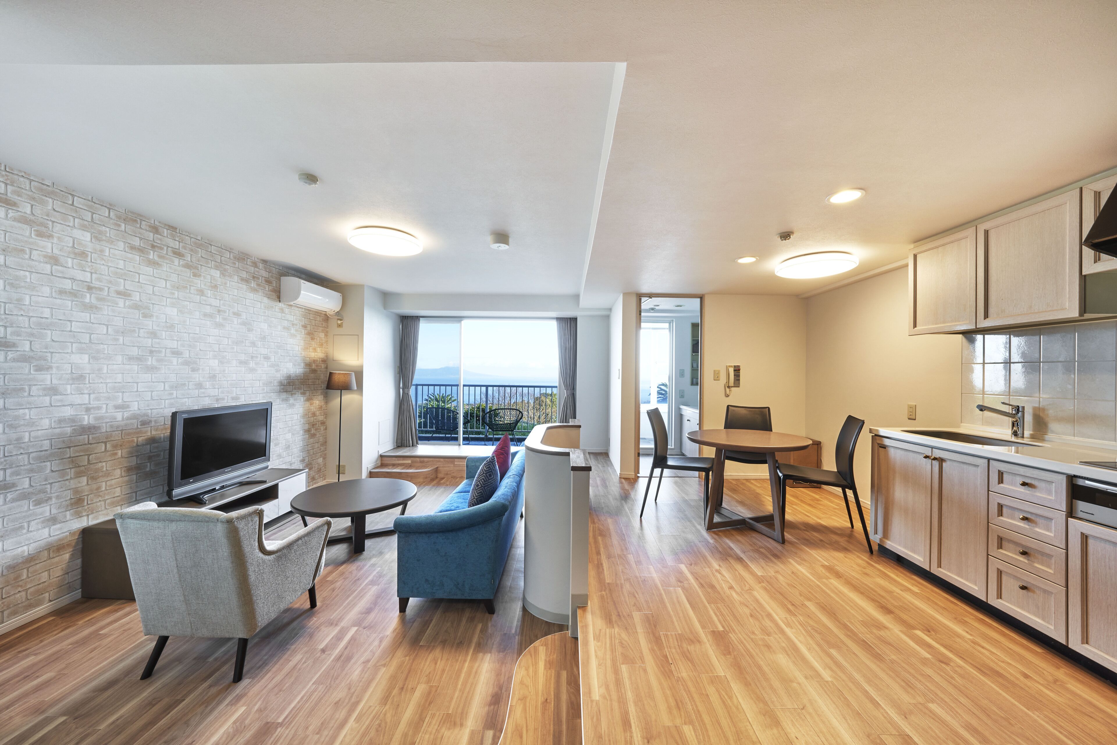 Um apartamento moderno com área de estar, cozinha e varanda.
