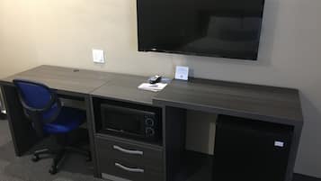 A modern office desk with a flat-screen TV, a blue office chair, and a small filing cabinet.