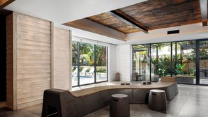 Ein moderner Lounge-Bereich mit einer gebogenen Sitzgruppe, großen Fenstern und einer Holzzieldecke.