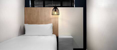 A bedroom with a wooden headboard, a bedside table, and a unique textured wall.