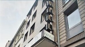 Façana d'hotel amb exterior de pedra, un senyal amb la paraula 'Hotel' i un altre senyal que indica un centre d'spa.