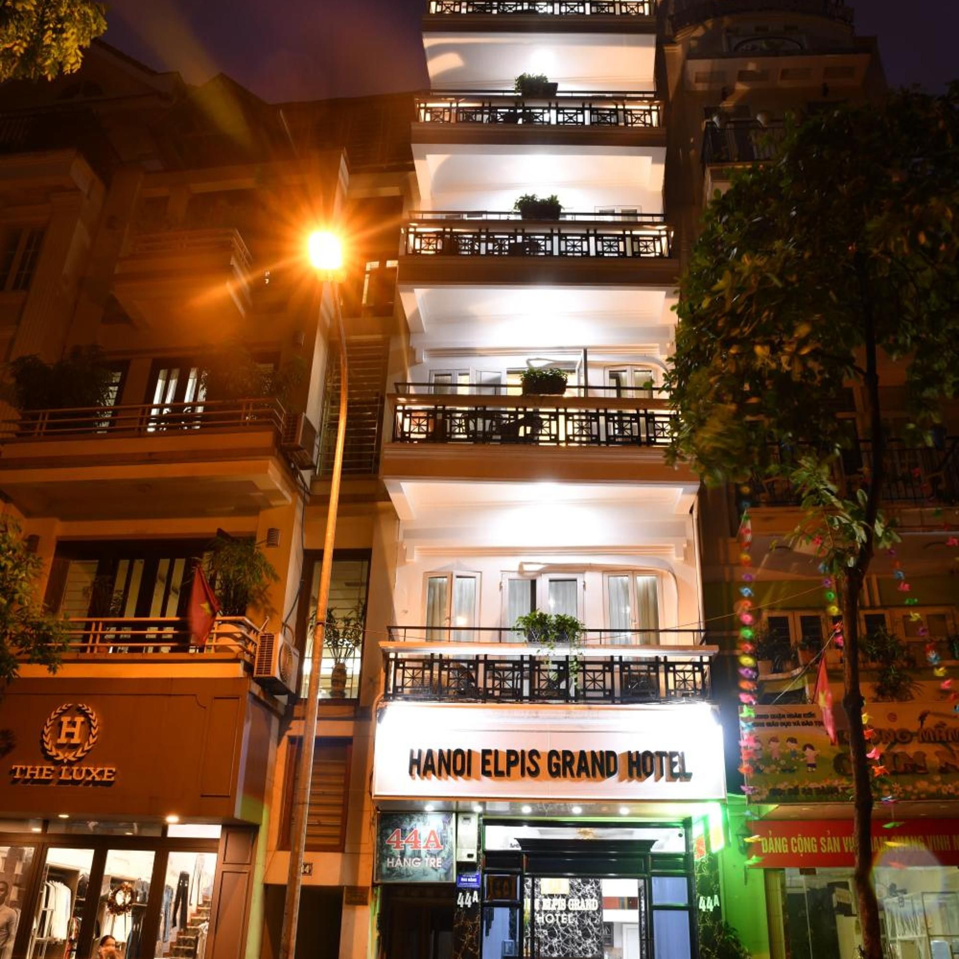 Hotel Elpis Grand Hanoi, con múltiples balcones, una entrada visible y vista a la calle.