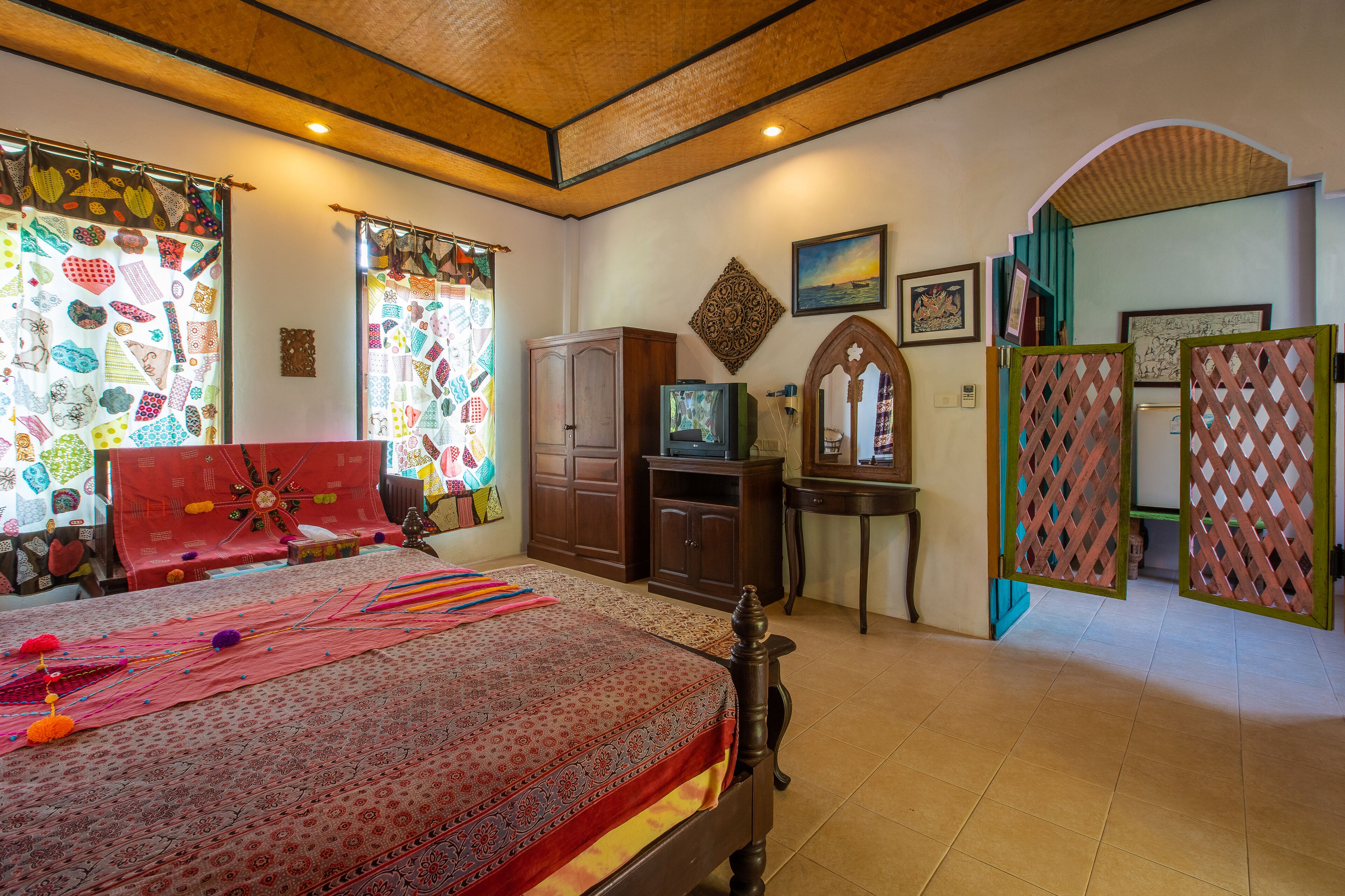 Un dormitorio con cama, armario, televisor y objetos decorativos.