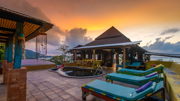 A rooftop pool area with lounge chairs and a covered seating area, overlooking a scenic view. - Varinda Garden Resort (Koh Samui)