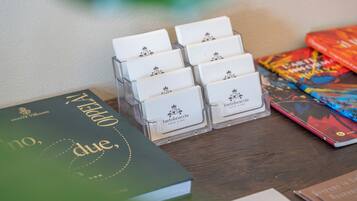 Una mesa de madera con una pila de libros, un juego de placas de identificación blancas y un libro colorido.