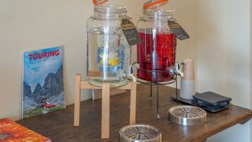 Two glass jars with water and juice, a book titled 'TOURING,' and a wooden chair.