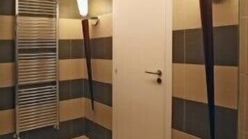 A hallway with a white door, striped walls, and a radiator.