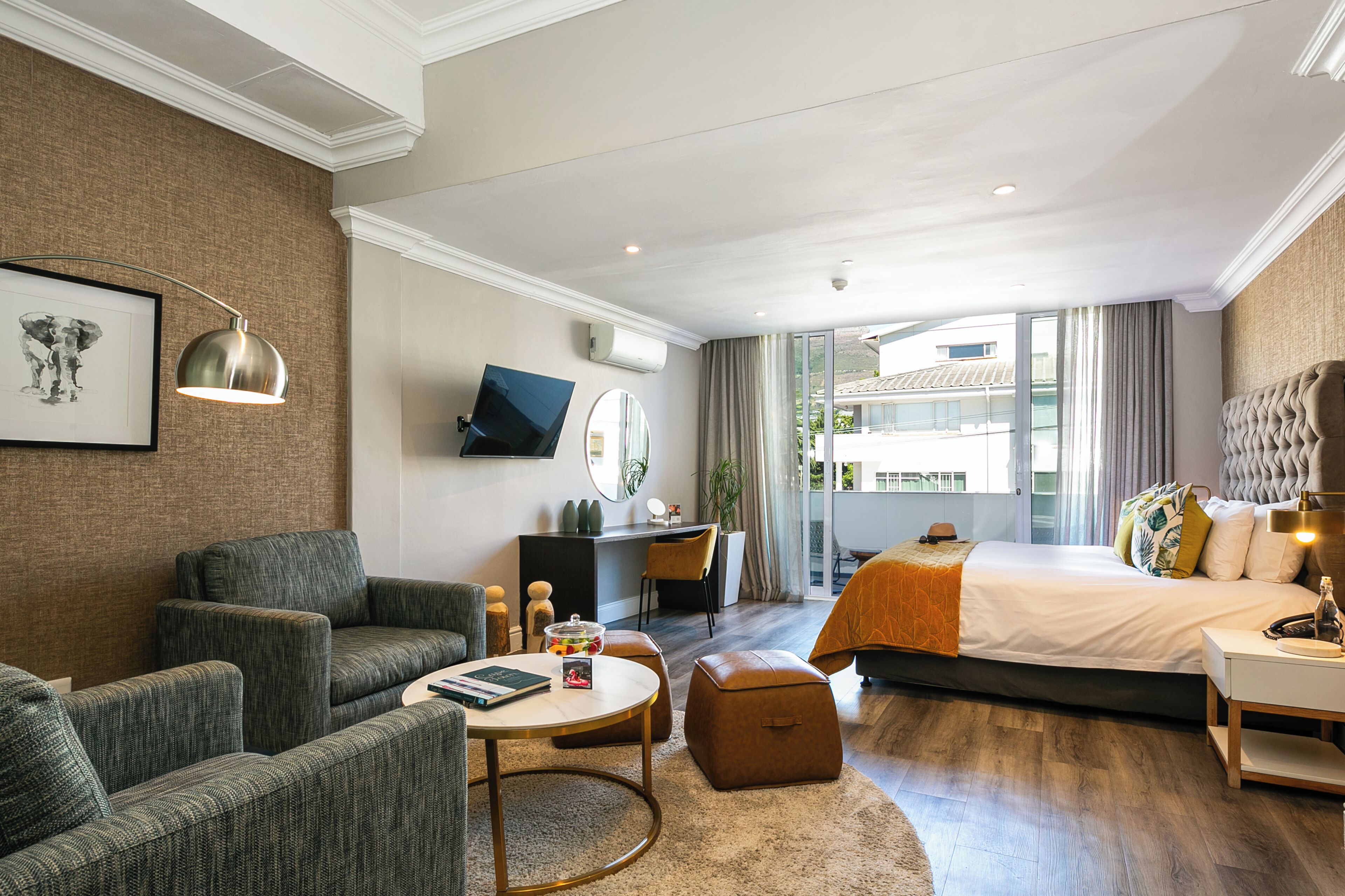 Une chambre d’hôtel moderne équipée d’un grand lit, d’un bureau, d’un canapé et d’une table basse.