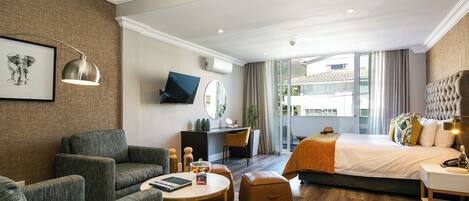 Une chambre d’hôtel moderne équipée d’un grand lit, d’un bureau, d’un canapé et d’une table basse.