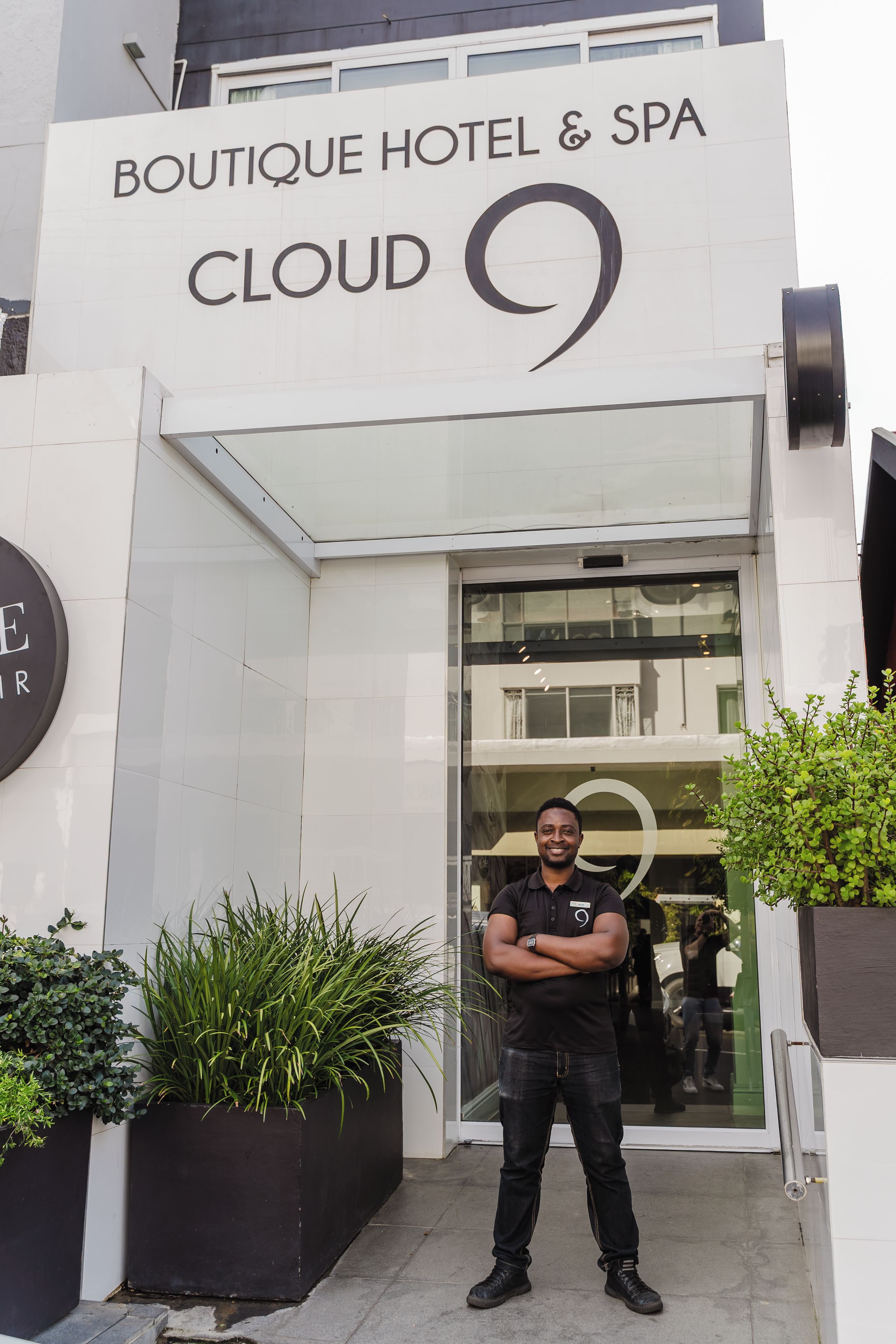 A man standing in front of Boutique Hotel & Spa Cloud 9.