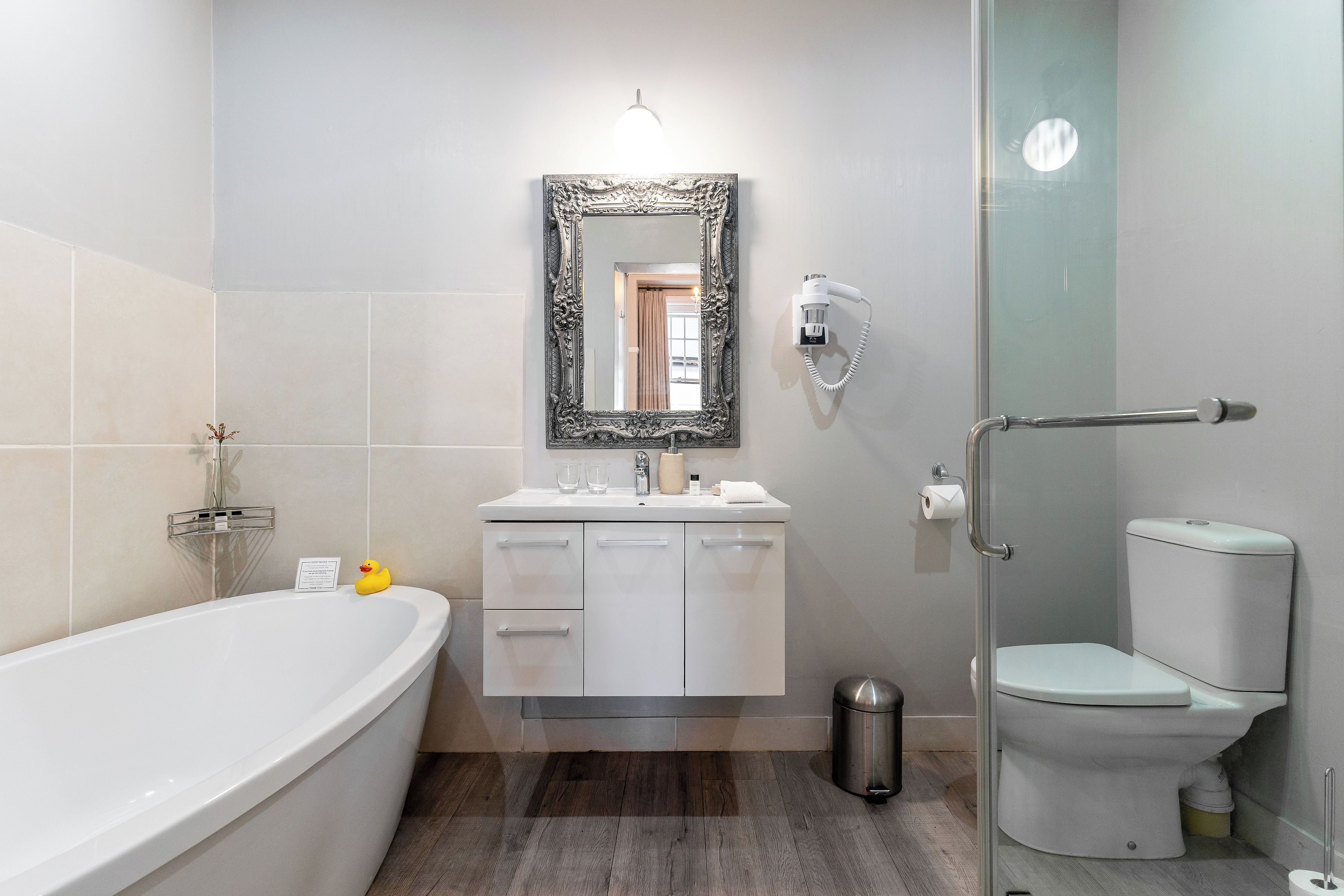 A modern bathroom with a freestanding bathtub, a vanity with a mirror, and a toilet.
