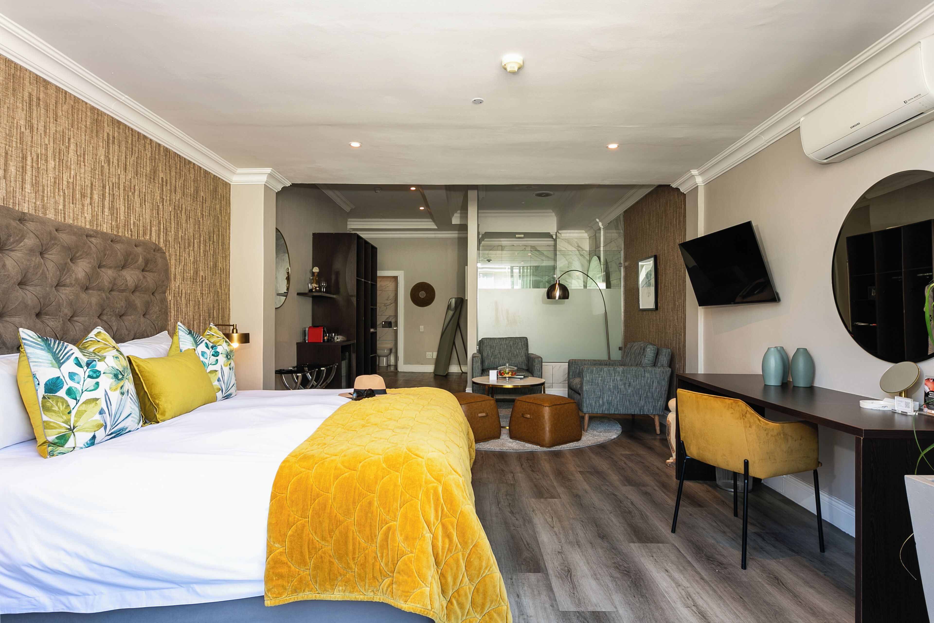 A hotel room with a large bed, a desk, a chair, and a television.