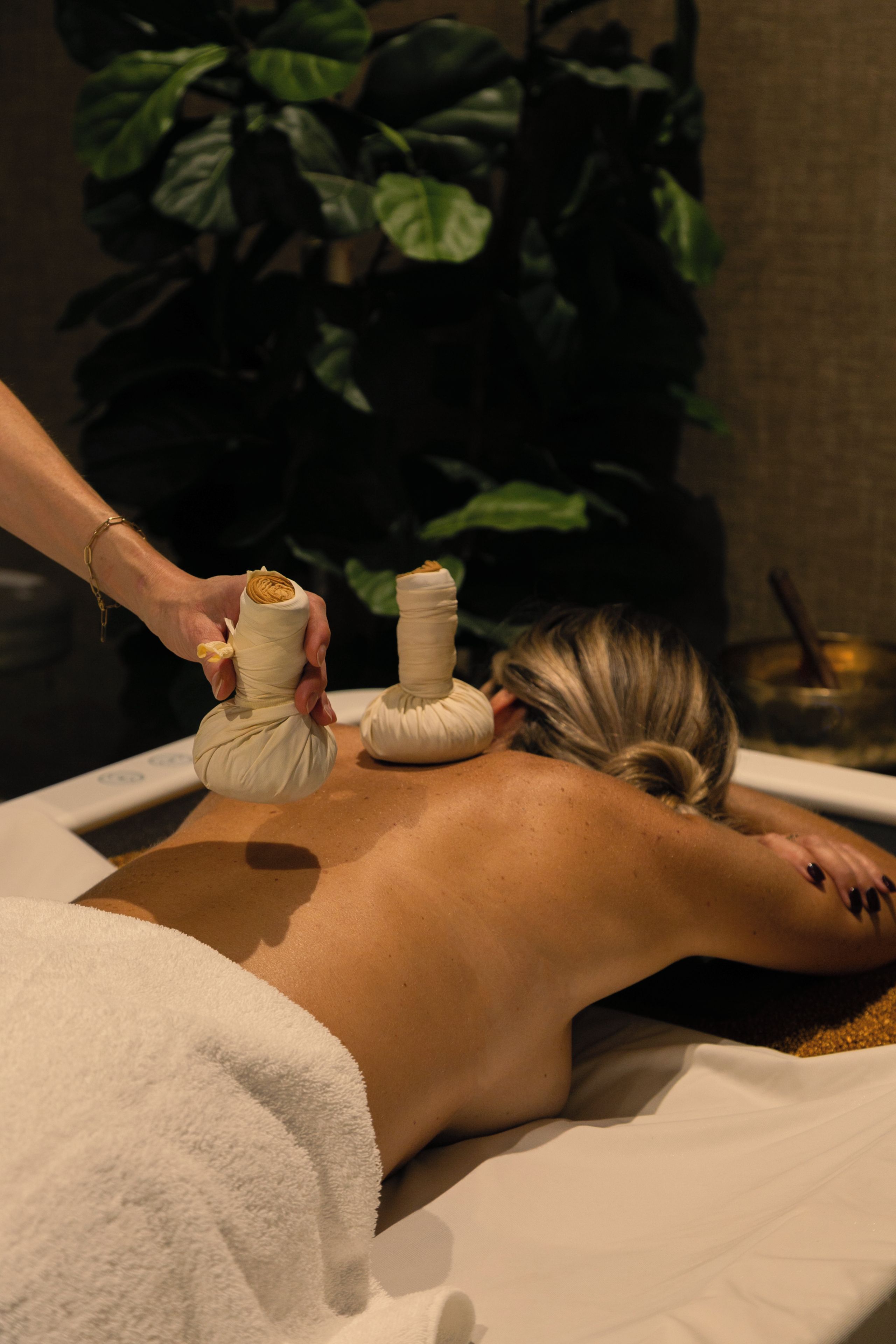 Eine Person erhält eine Massage, wobei der Unterkörper mit einem Handtuch bedeckt ist.
