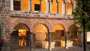 A courtyard with stone arches, a stone wall, and a seating area with tables and chairs. - Casa Cartagena Boutique Hotel & Spa (Cusco)