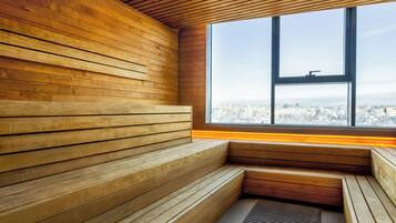 Zona con bancos de madera y un amplio ventanal con vista a la ciudad.