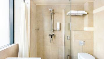Un baño moderno con ducha acristalada, inodoro blanco y bañera.