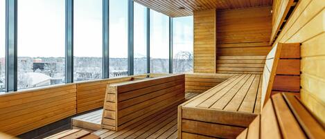 Un interior moderno con bancos de madera y ventanas amplias que ofrecen vistas a la ciudad.