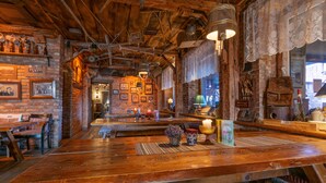 A rustic interior with exposed brick walls, wooden tables, and hanging light fixtures.