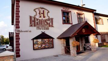 Ein Gebäude mit einem Schild, das „Hansa Hotel“ zeigt, und einem kleinen Eingang mit einer Ziegel-Fassade.